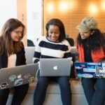 three woman in front of laptop computer